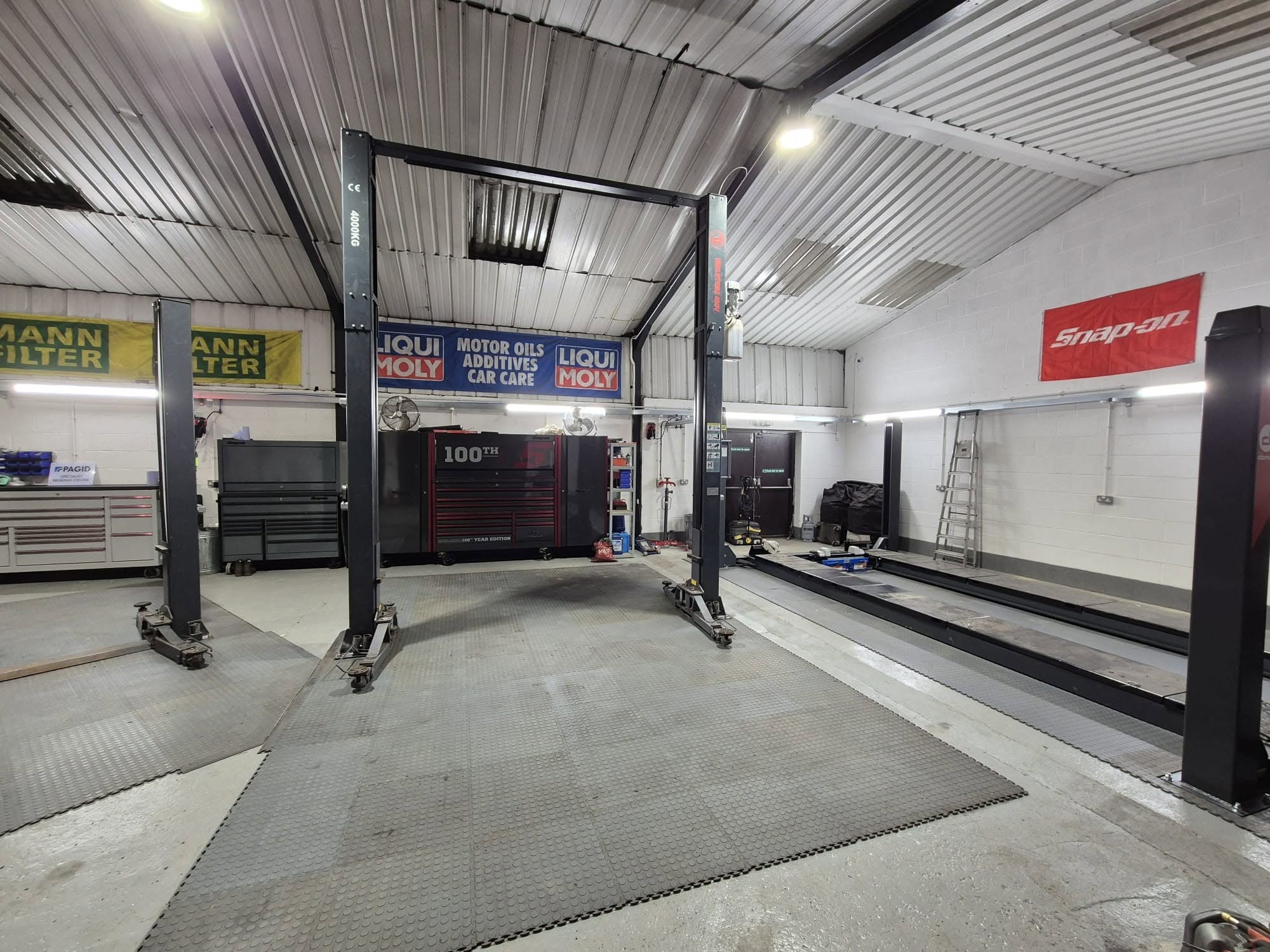 The new workshop with an empty two-post lift, Liqui Moly and Mann Filter banners and red Snap-on sign