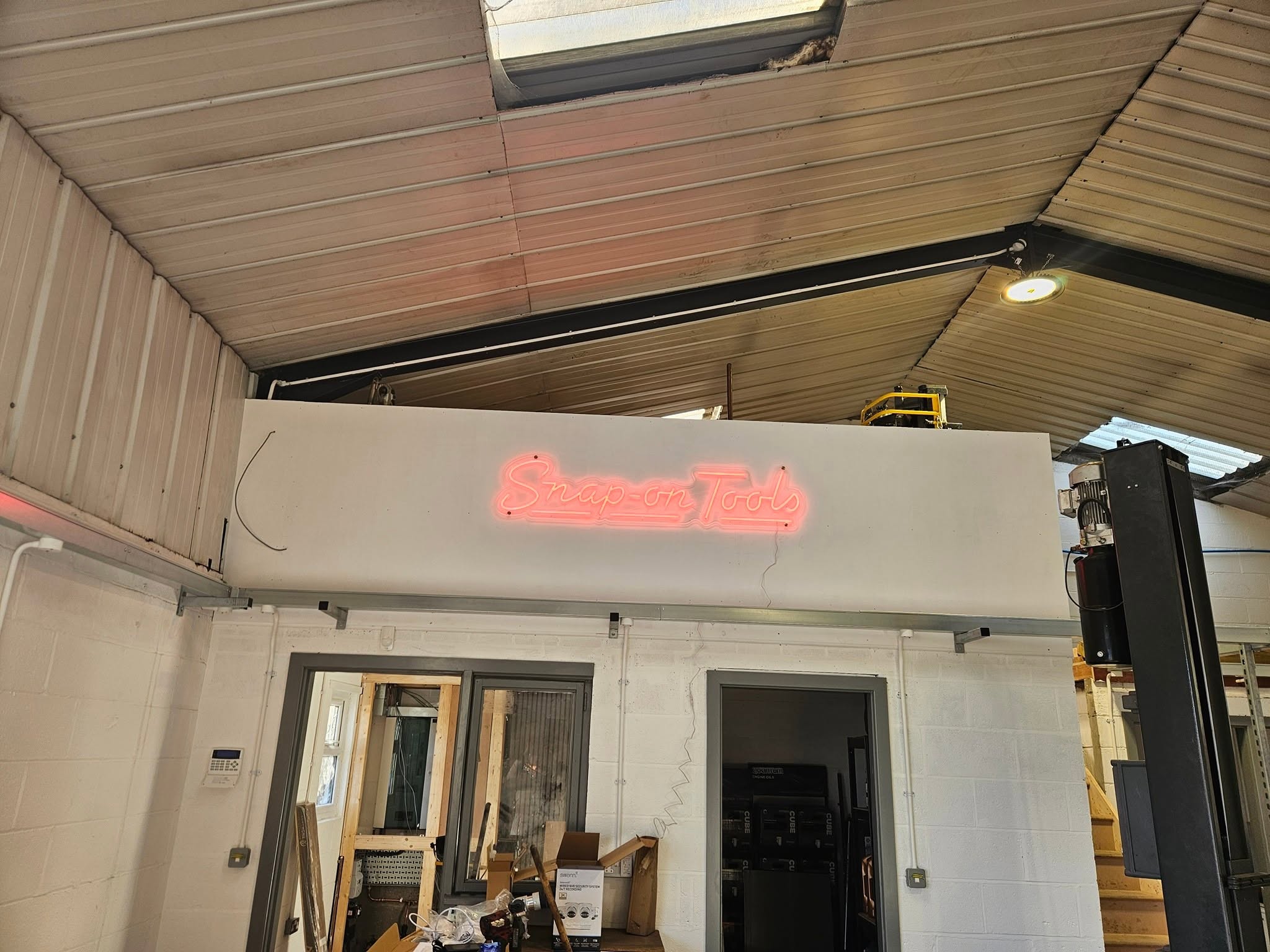 A red Snap-on Tools neon sign glowing above the office doors in the new workshop
