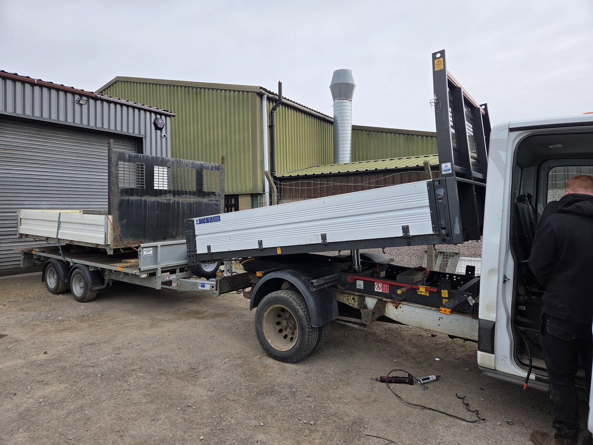 A white pick-up in the yard with its old tipper body lifted off onto a trailer and the new aluminium tipper fitted